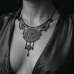 Tatuagens femininas. Tatuagem ornamental estilo mandala na região do esterno (underboob), com detalhes em pontilhismo que imitam uma joia.