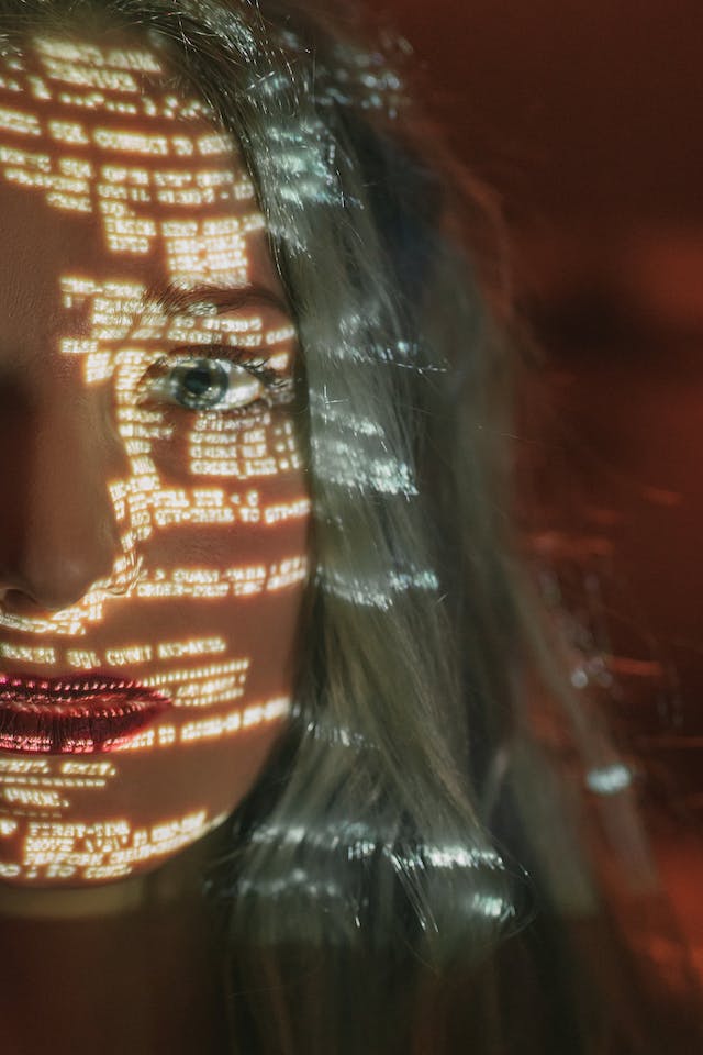 segurança-online Imagem de uma tela de computador com códigos de programação refletindo o rosto de uma jovem. Segurança digital.