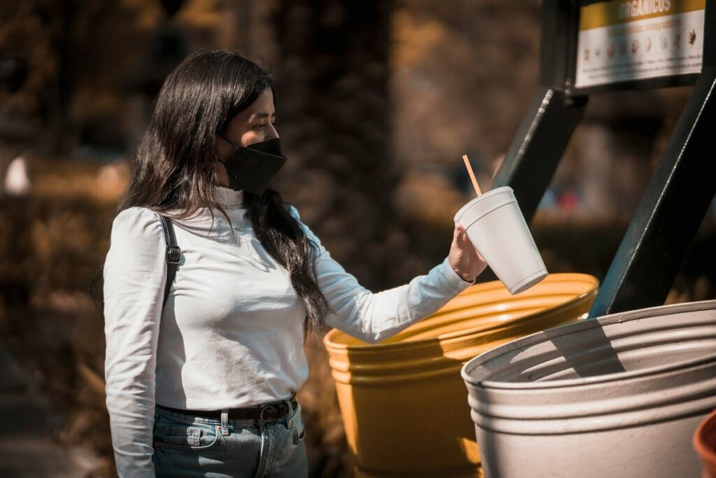 Pessoa descartando plástico para reciclagem