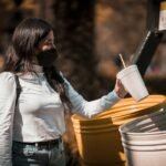 Pessoa descartando plástico para reciclagem